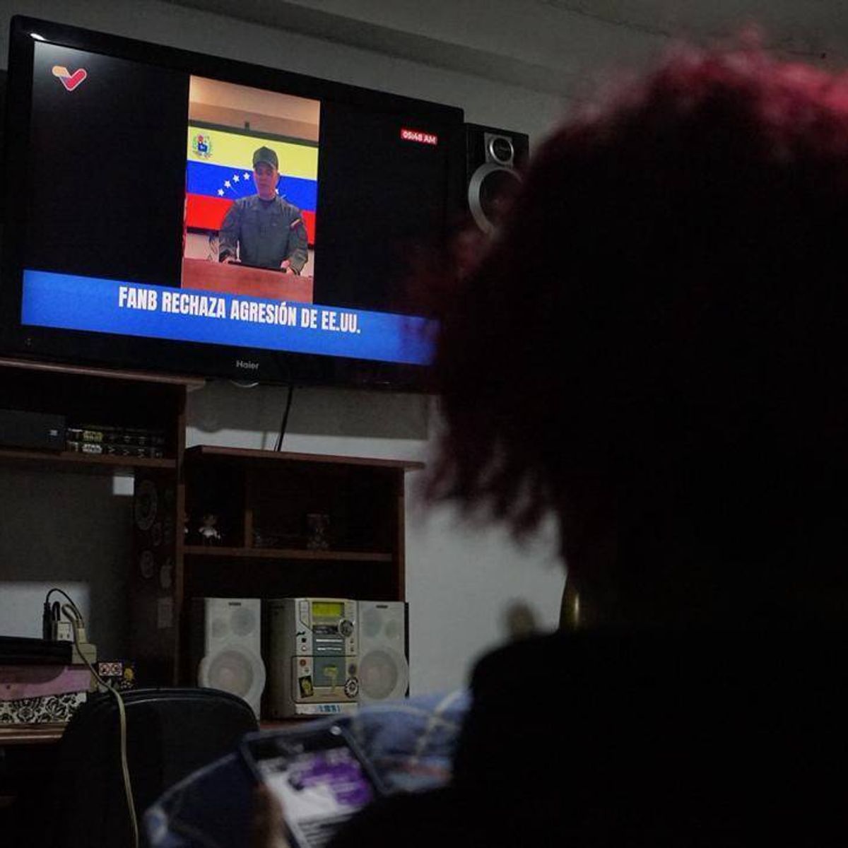 A woman watches a public television broadcast by Venezuelan Defense Minister Vladimir Padrino