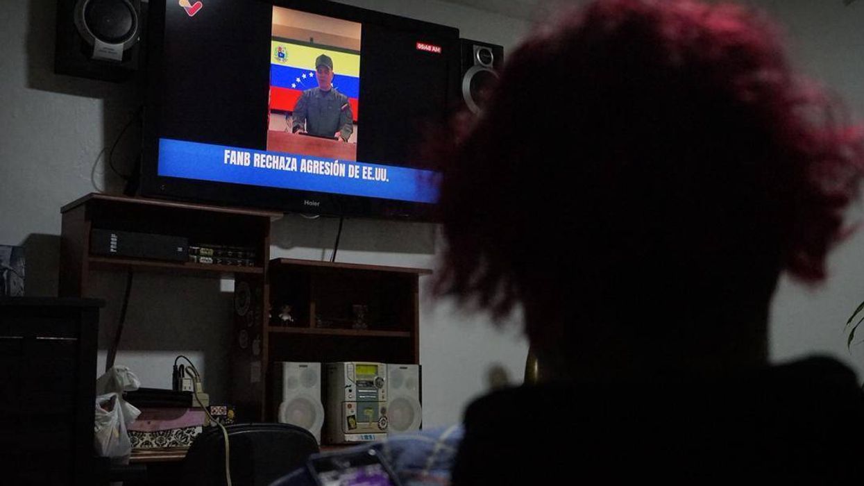 A woman watches a public television broadcast by Venezuelan Defense Minister Vladimir Padrino