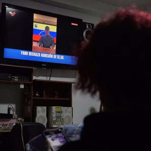 A woman watches a public television broadcast by Venezuelan Defense Minister Vladimir Padrino