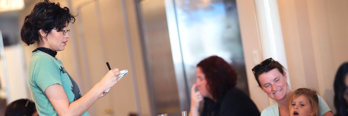 A worker at a restaurant takes an order