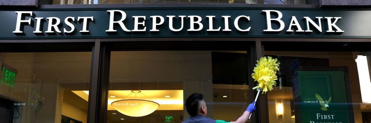 A worker cleans the exterior of a First Republic bank