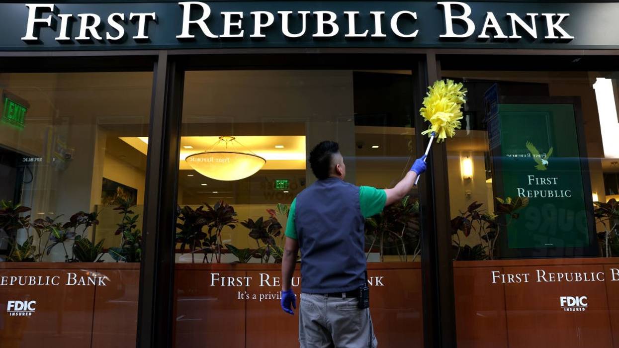 A worker cleans the exterior of a First Republic bank
