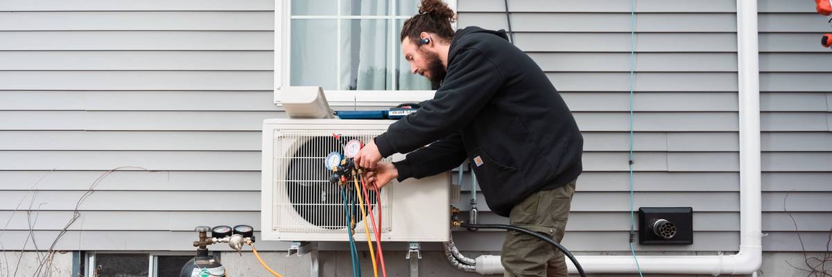A worker installs a heat pump in Maine.