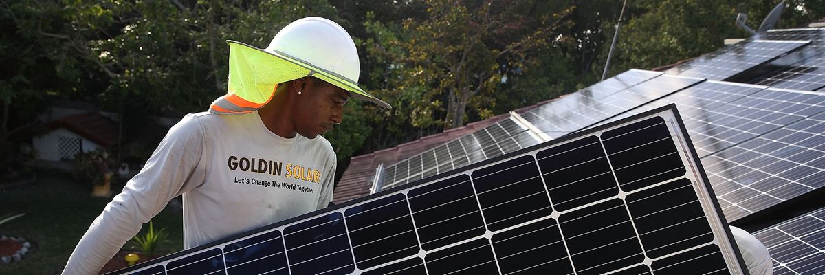 A worker installs solar panels.
