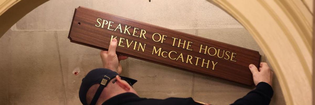 A worker replaces a sign over the office of U.S. Speaker of the House Kevin McCarthy 