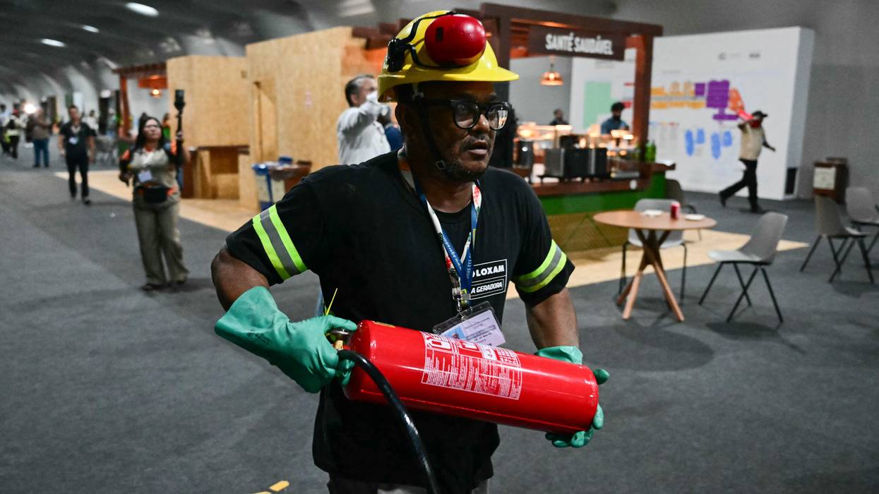 A worker runs to put out COP fire.