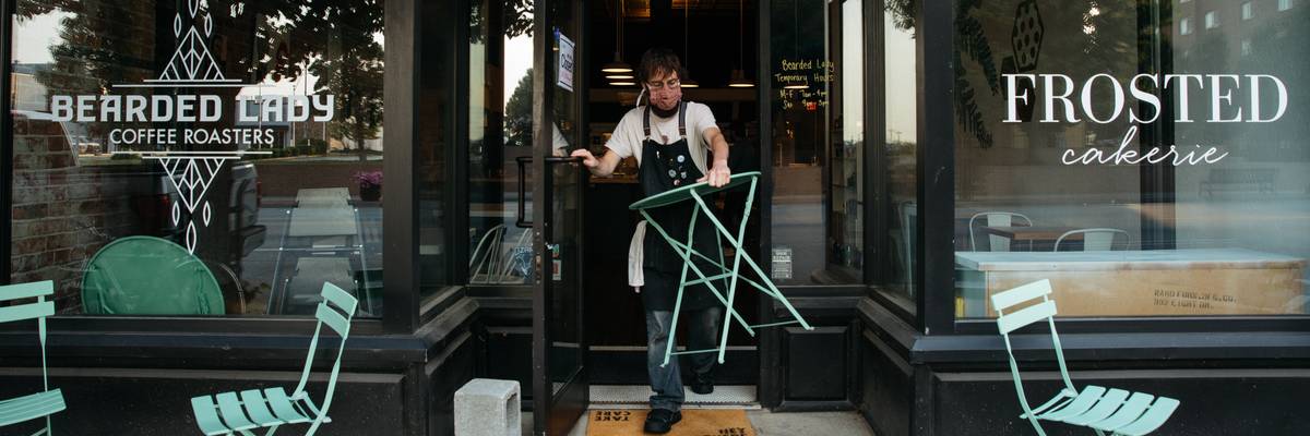 A worker sets up seating outside of a storefront in Joplin, Missouri.
