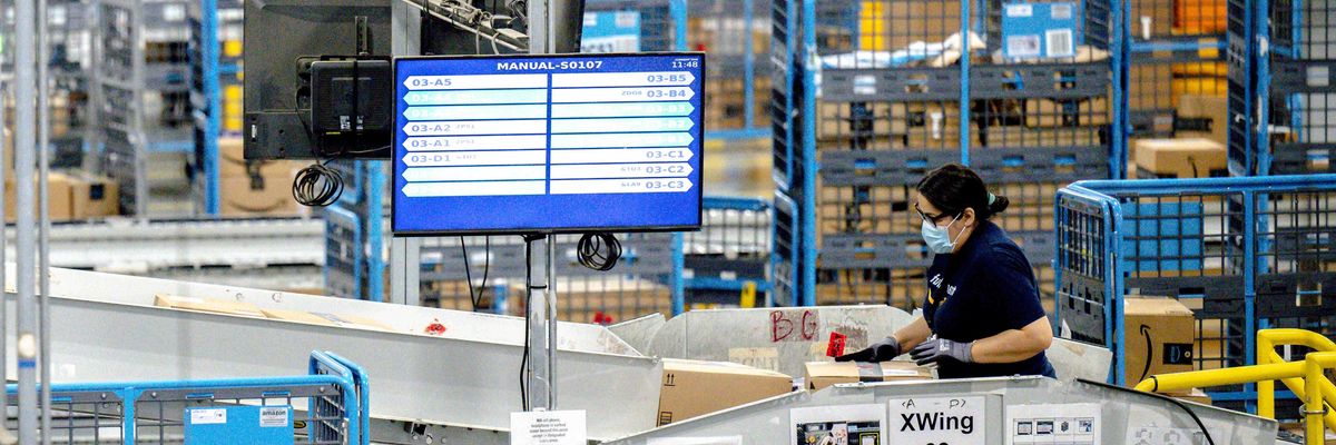 A worker sorts parcels in the outbound dock at Amazon fulfillment center