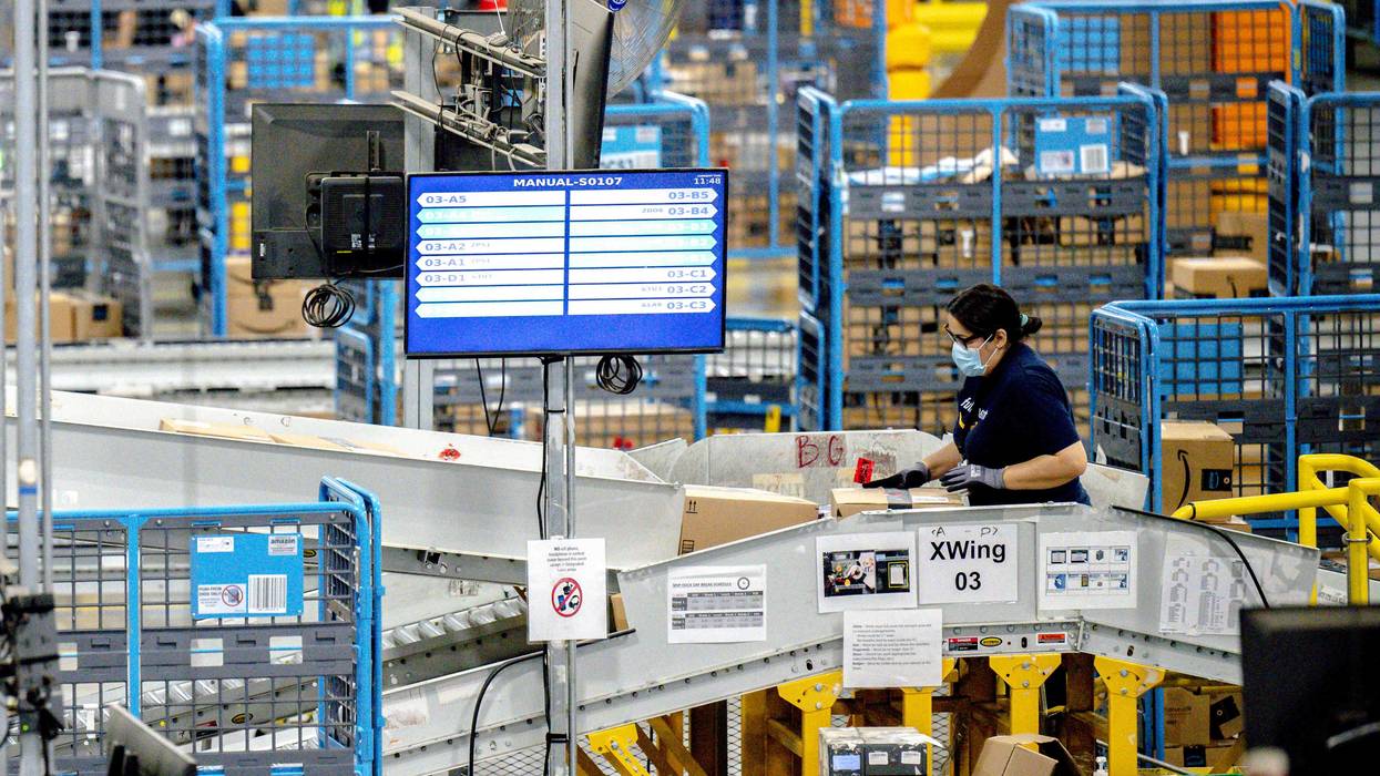 A worker sorts parcels in the outbound dock at Amazon fulfillment center