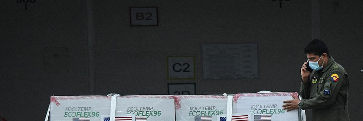 A worker unloads a shipment of coronavirus vaccines