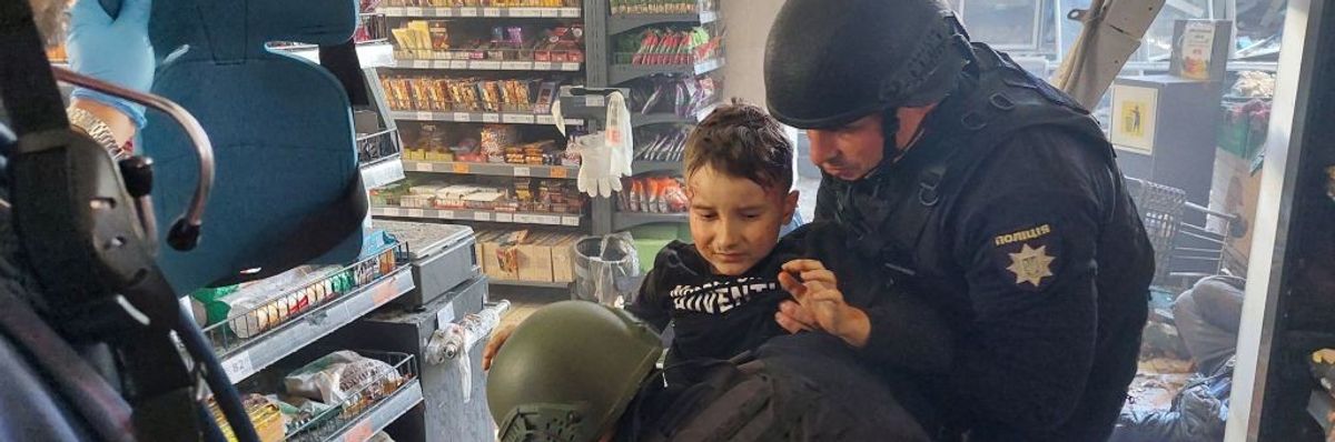 https://www.commondreams.org/media-library/a-wounded-child-is-helped-by-police-officers-at-a-local-supermarket-following-a-russian-strike-in-the-southern-ukrainian-town-of.jpg?id=33592066&width=1200&height=400&quality=90&coordinates=0%2C101%2C0%2C242