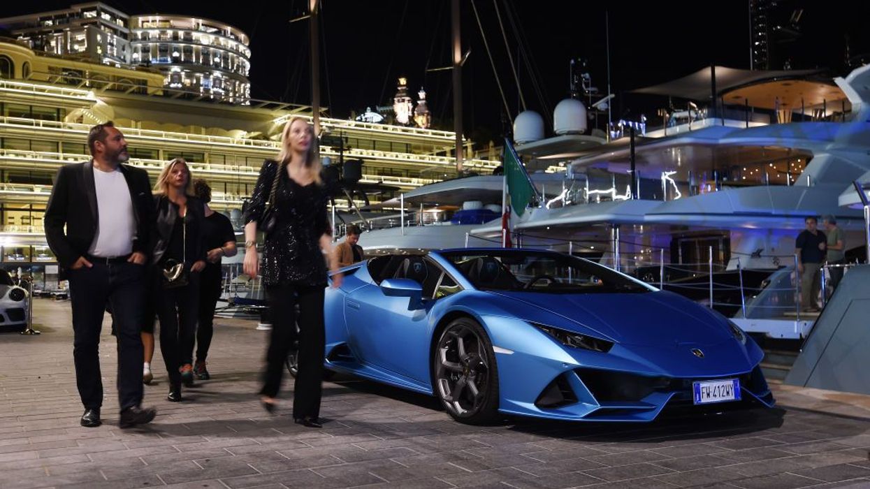 A yacht party in Monaco with a Lamboghini parked by vessels
