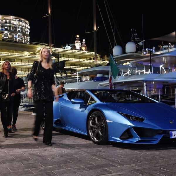 A yacht party in Monaco with a Lamboghini parked by vessels