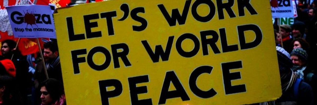 A yellow sign reading "Let's Work For World Peace." in black letters.