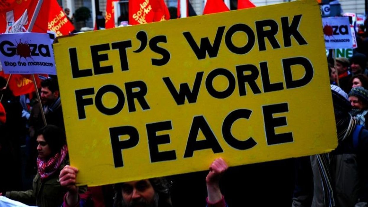 A yellow sign reading "Let's Work For World Peace." in black letters.