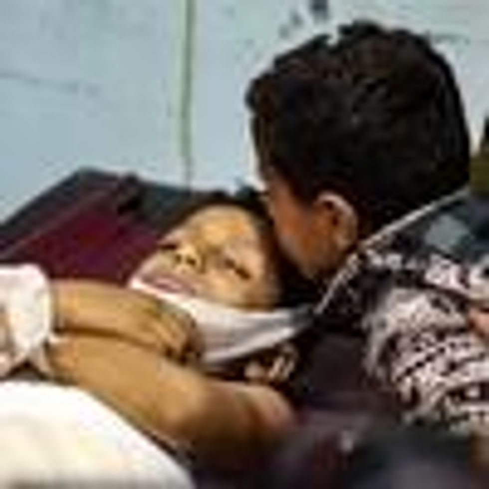 A Yemeni boy kisses the forehead of a killed youngster
