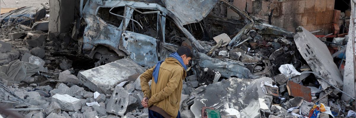 A Yemeni inspects the damage caused by a Saudi-led airstrike