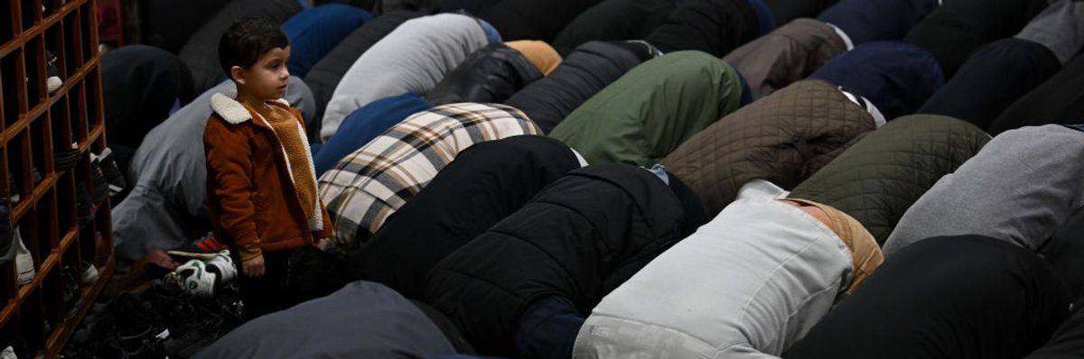 A young boy watches as people pray during a funeral service for 6-year-old