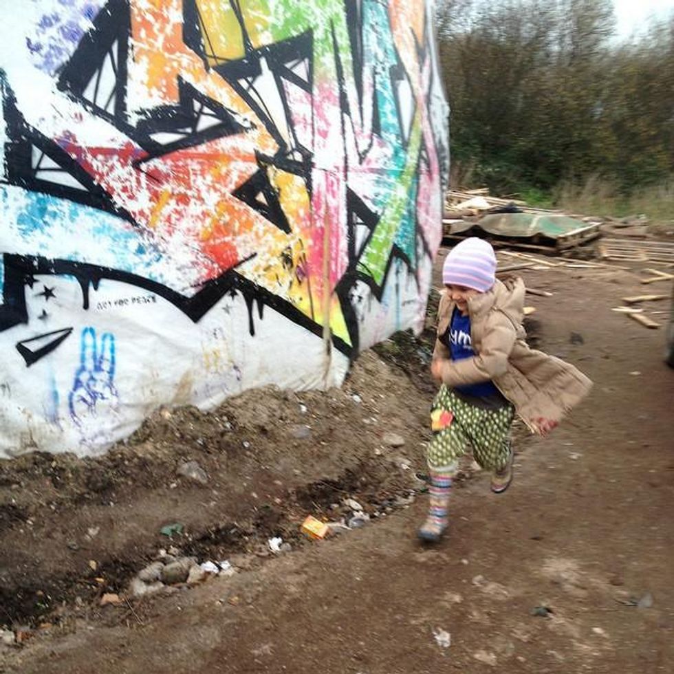 A young girl enjoys herself, running around a makeshift children's art center tucked in