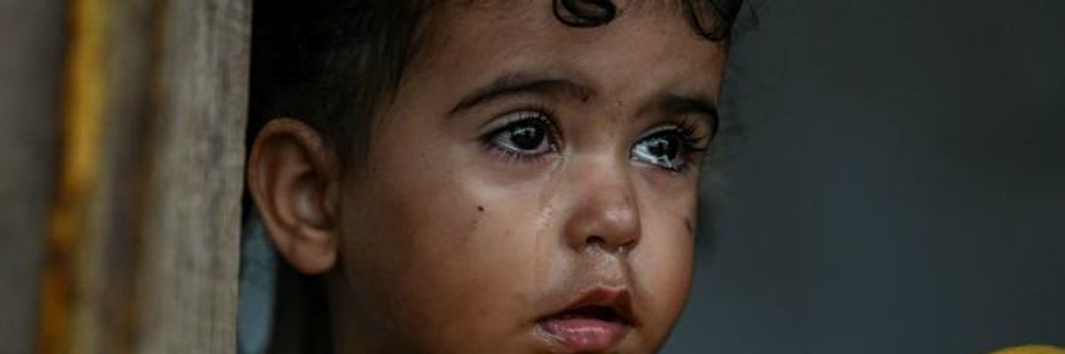 A young girl stands inside a tent at a makeshift camp next to the camp of Moria in the island of Lesbos on November 30, 2019