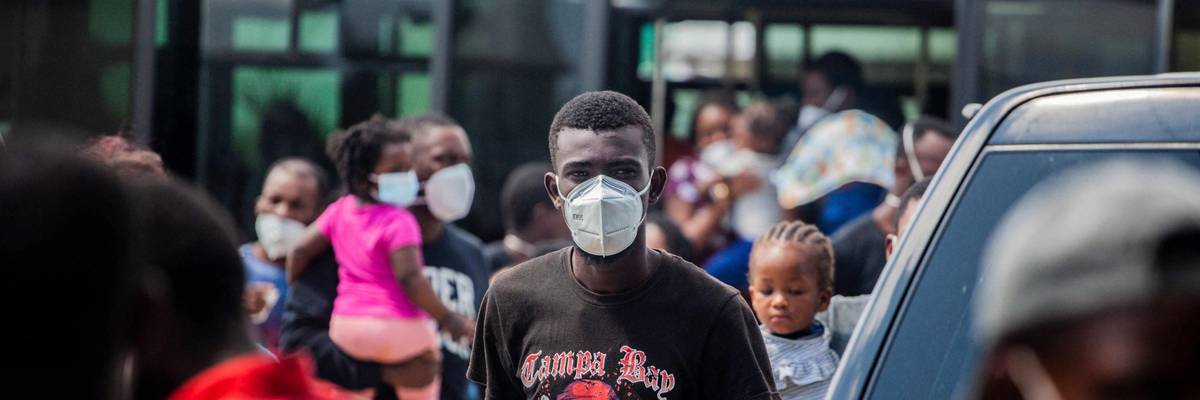 A young Haitian migrant stands in a crowd in Port-au-Prince following his deportation from the US