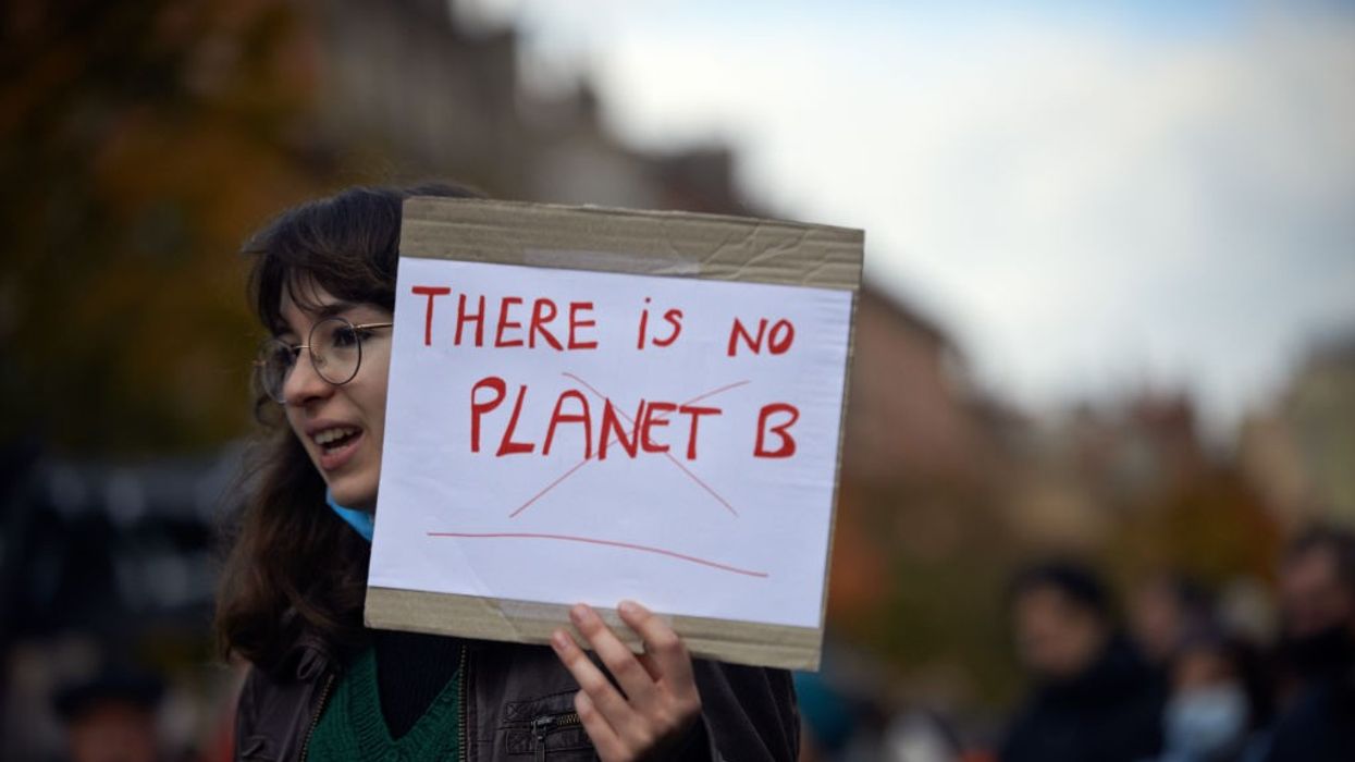 A young woman holds a sheet 'There is no Planet B'.