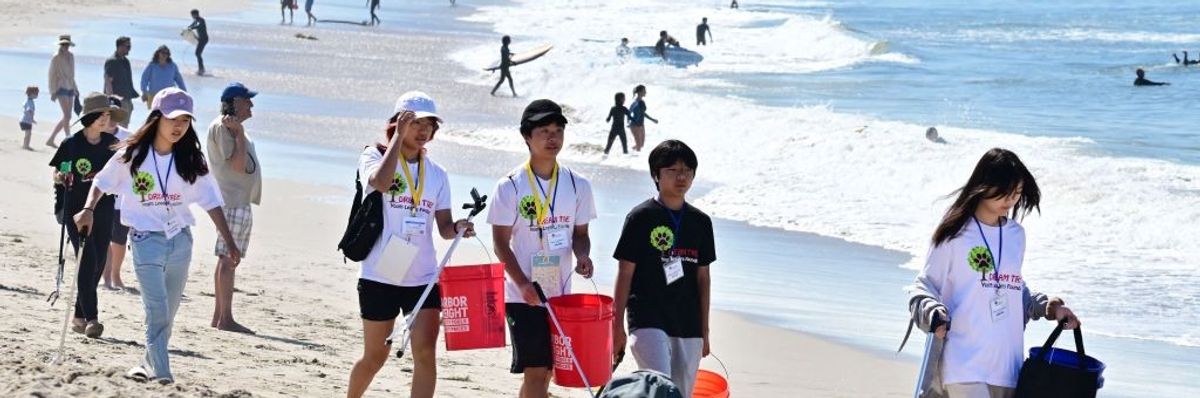A youth group participate in cleaning up trash at Venice Beach for Earth Day on April 22, 2023, in Los Angeles, California.