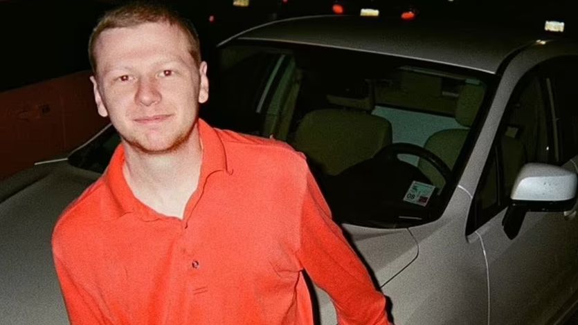 Aaron Bushnell poses for a photo in a red shirt