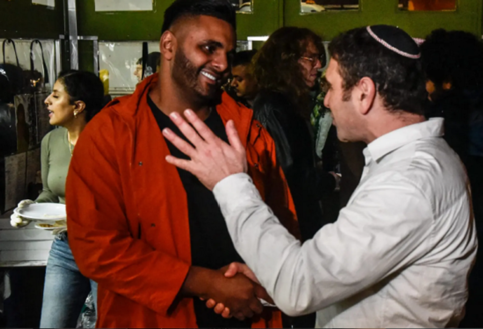 Abdul Elenani, owner of Palestinian restaurant Ayat, greets a Jewish neighbor