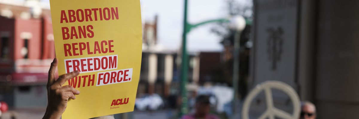 Abortion rights activist holds a placard saying, Abortion