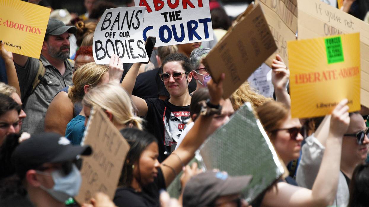 Abortion rights activists hoist their signs outside the U.S. Supreme Court in Washington, D.C. on June 24, 2022.