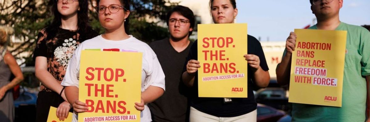 abortion rights activists hold placards