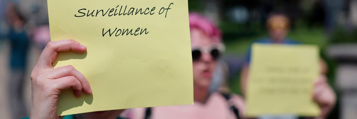 Abortion rights protest, sign readig "abolish patriarchal surveillance of women"