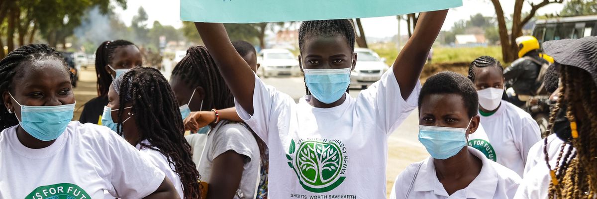 Activist holding sign reading, "System change not climate change"