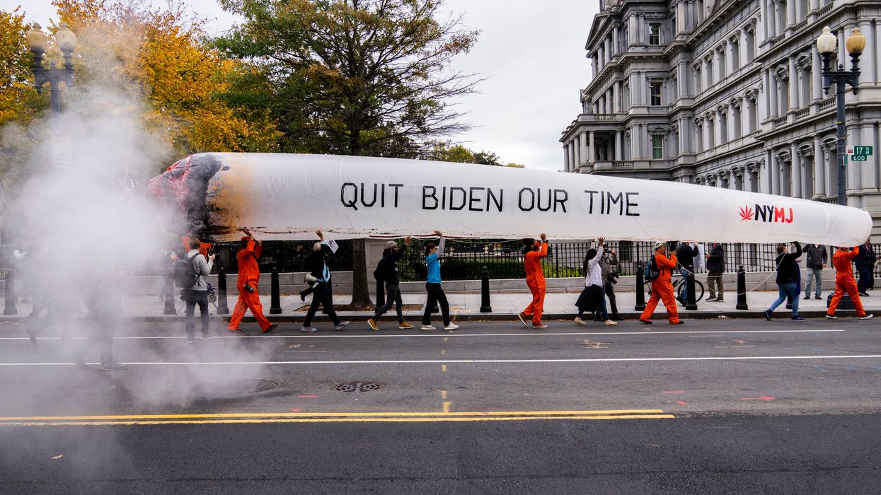 Activists carry a giant inflatable joint reading "Quit Biden Our Time" as they march in Washington.