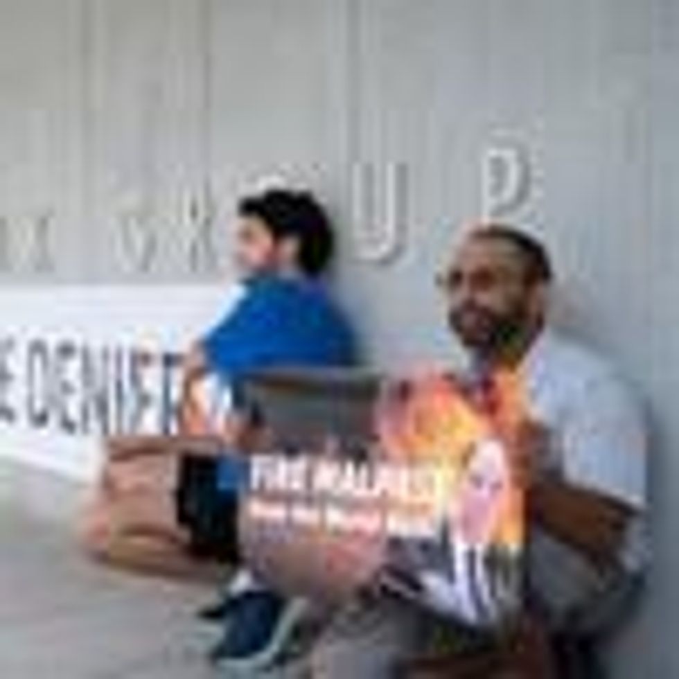 Activists display a banner describing World Bank President David Malpass as a climate denier in front of the bank's headquarters in Washington, D.C. on September 22, 2022.