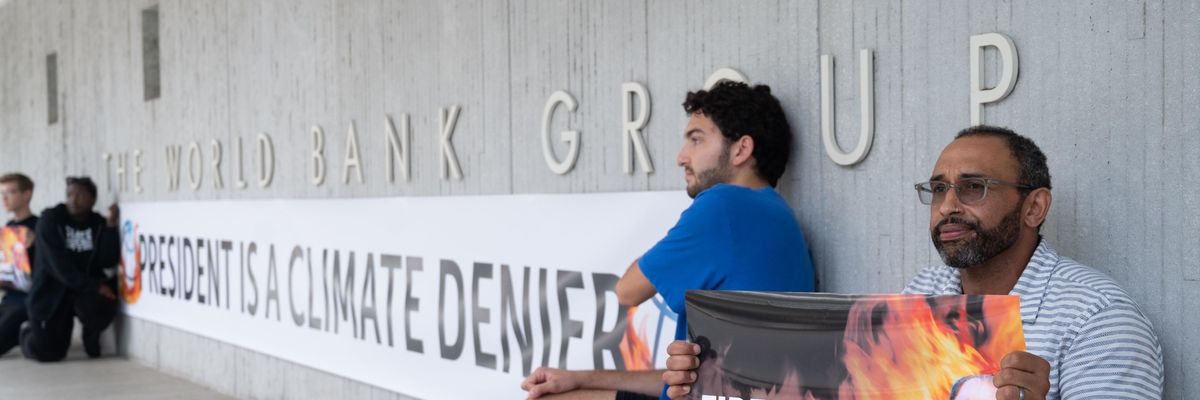 Activists display a banner describing World Bank President David Malpass as a climate denier in front of the bank's headquarters in Washington, D.C. on September 22, 2022.