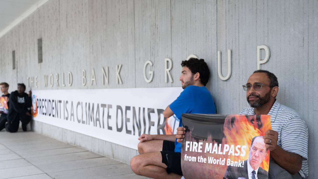Activists display a banner describing World Bank President David Malpass as a climate denier in front of the bank's headquarters in Washington, D.C. on September 22, 2022.