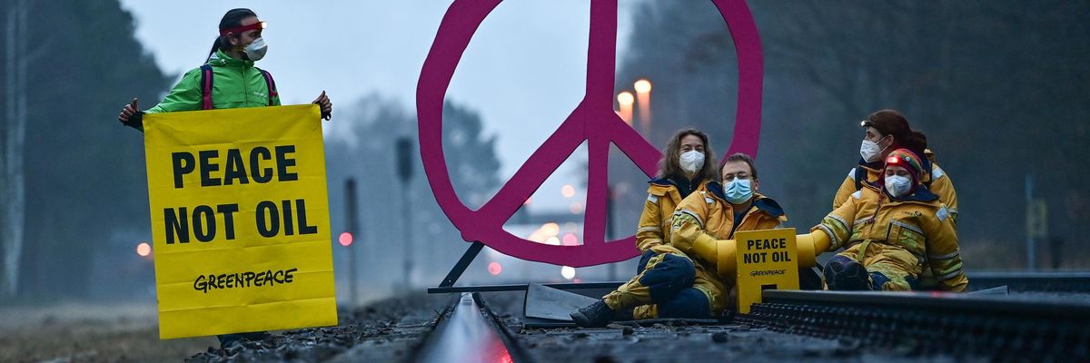 Activists from Greenpeace block a rail track leading to the oil refinery of PCK-Raffinerie GmbH in Germany on March 15, 2022 to protest against fossil imports from Russia and the indirect financing of the war in Ukraine. (Photo: Patrick Pleul/dpa-Zentralbild/ZB via Getty Images)