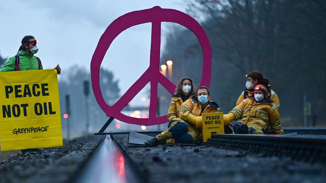 Activists from Greenpeace block a rail track leading to the oil refinery of PCK-Raffinerie GmbH in Germany on March 15, 2022 to protest against fossil imports from Russia and the indirect financing of the war in Ukraine. (Photo: Patrick Pleul/dpa-Zentralbild/ZB via Getty Images)