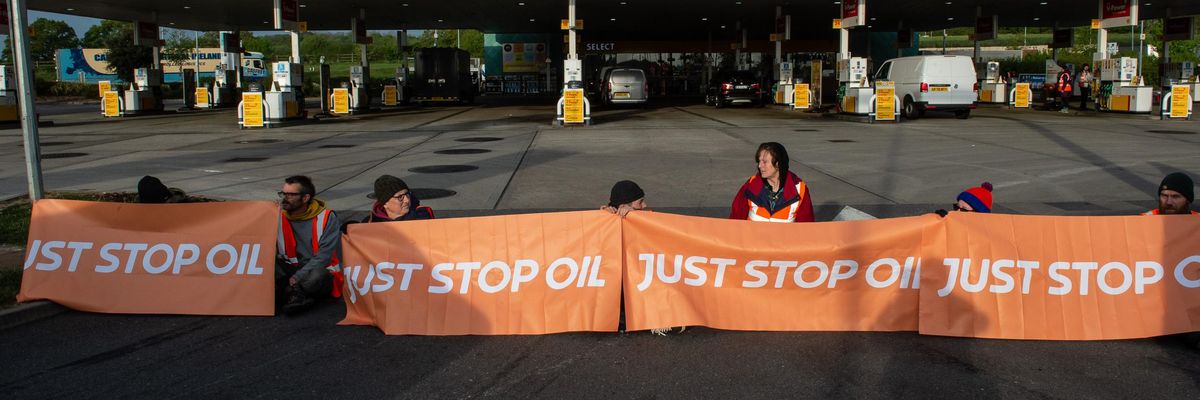 Activists from Just Stop Oil block the entrance to a Shell gas station on April 28, 2022 in Cobham, England.