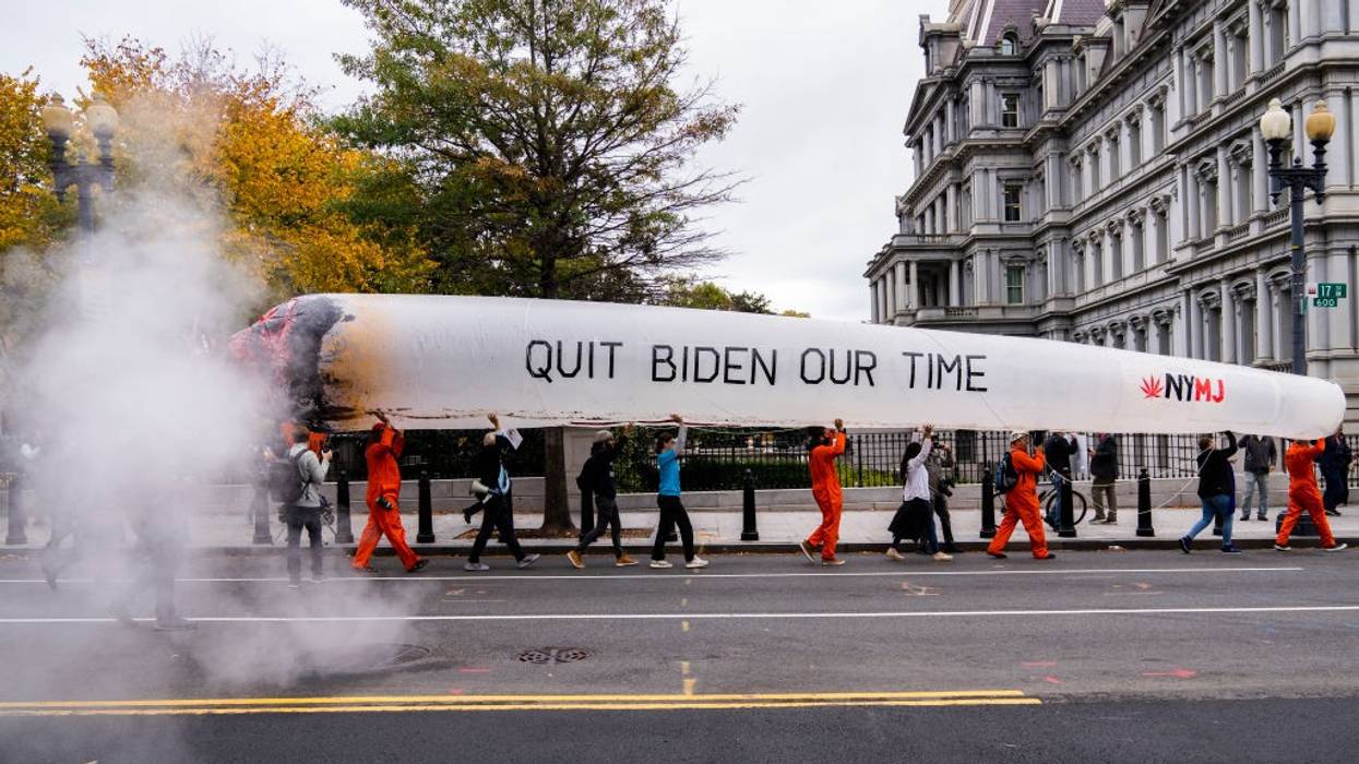 Activists hold a giant mock joint saying "quit Biden our time" as they march in Washintgon, D.C.