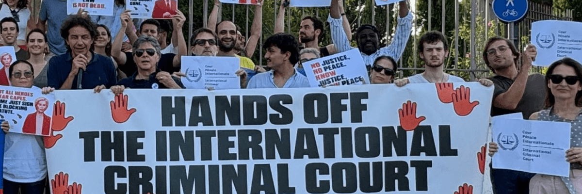Activists hold a sign reading 'Hands Off the International Criminal Court'