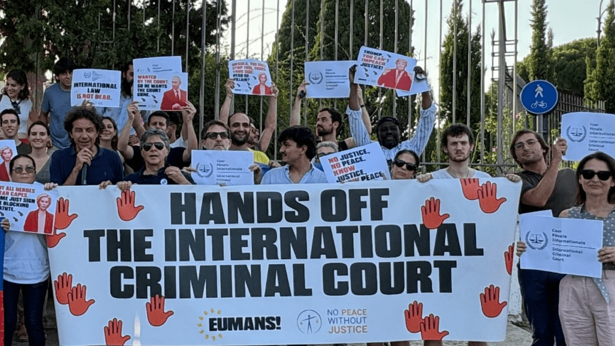 Activists hold a sign reading 'Hands Off the International Criminal Court'