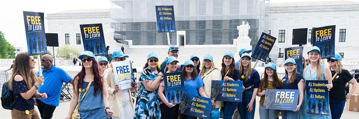Activists hold "free to learn" signs