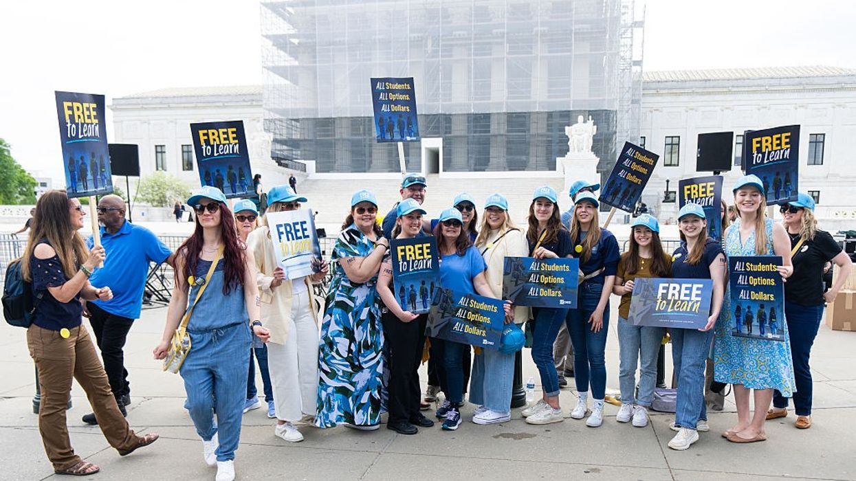 Activists hold "free to learn" signs