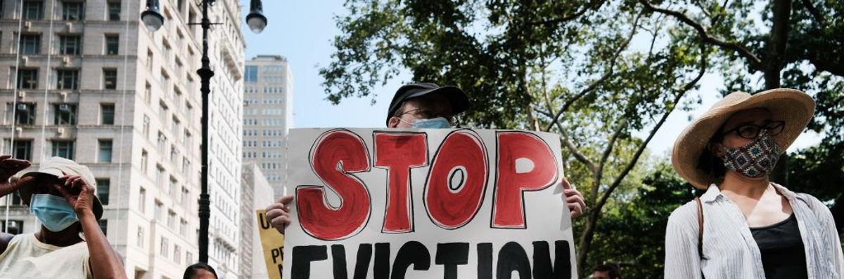 Activists hold sign that says "Stop Eviction" in New York City
