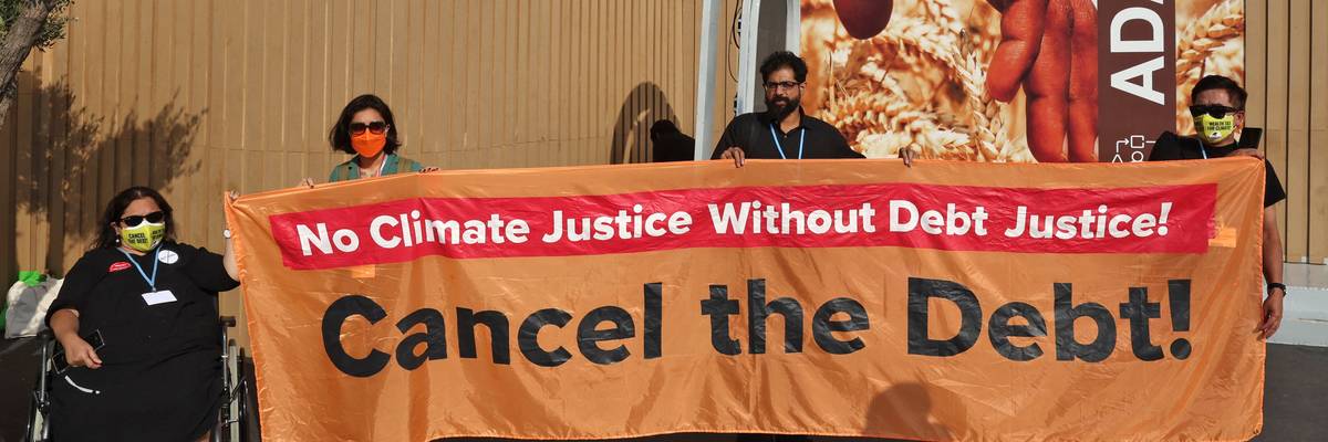 Activists hold up a banner demanding the cancellation of Global South nations' debt during the COP27 climate conference in Sharm El-Sheikh, Egypt on November 16, 2022. 