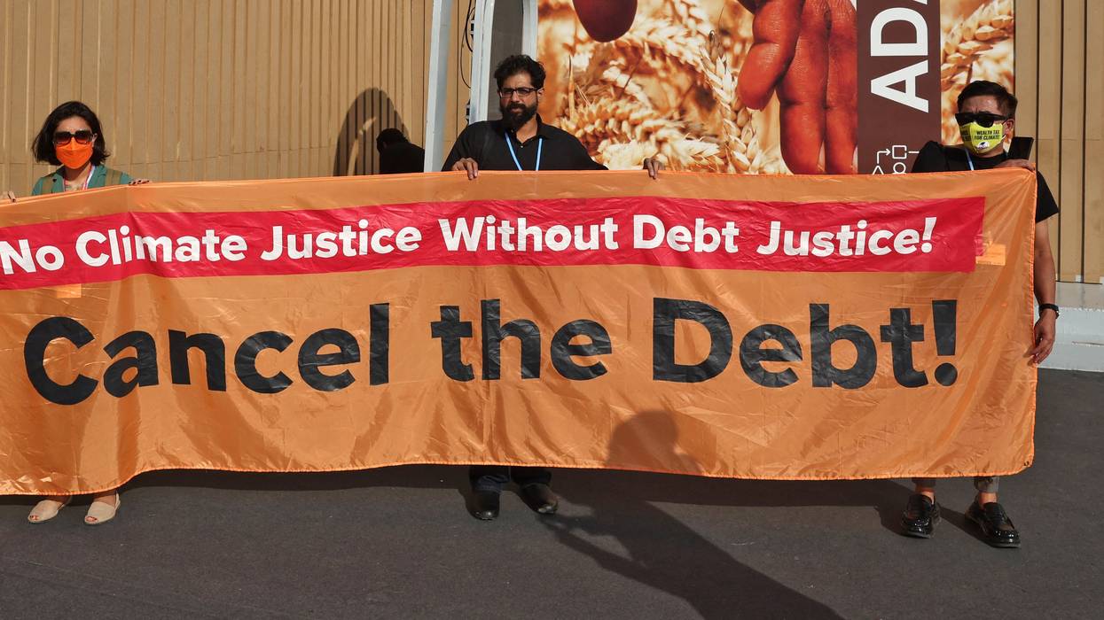 Activists hold up a banner demanding the cancellation of Global South nations' debt during the COP27 climate conference in Sharm El-Sheikh, Egypt on November 16, 2022. 
