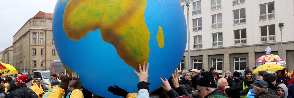 Activists hold up a large globe.